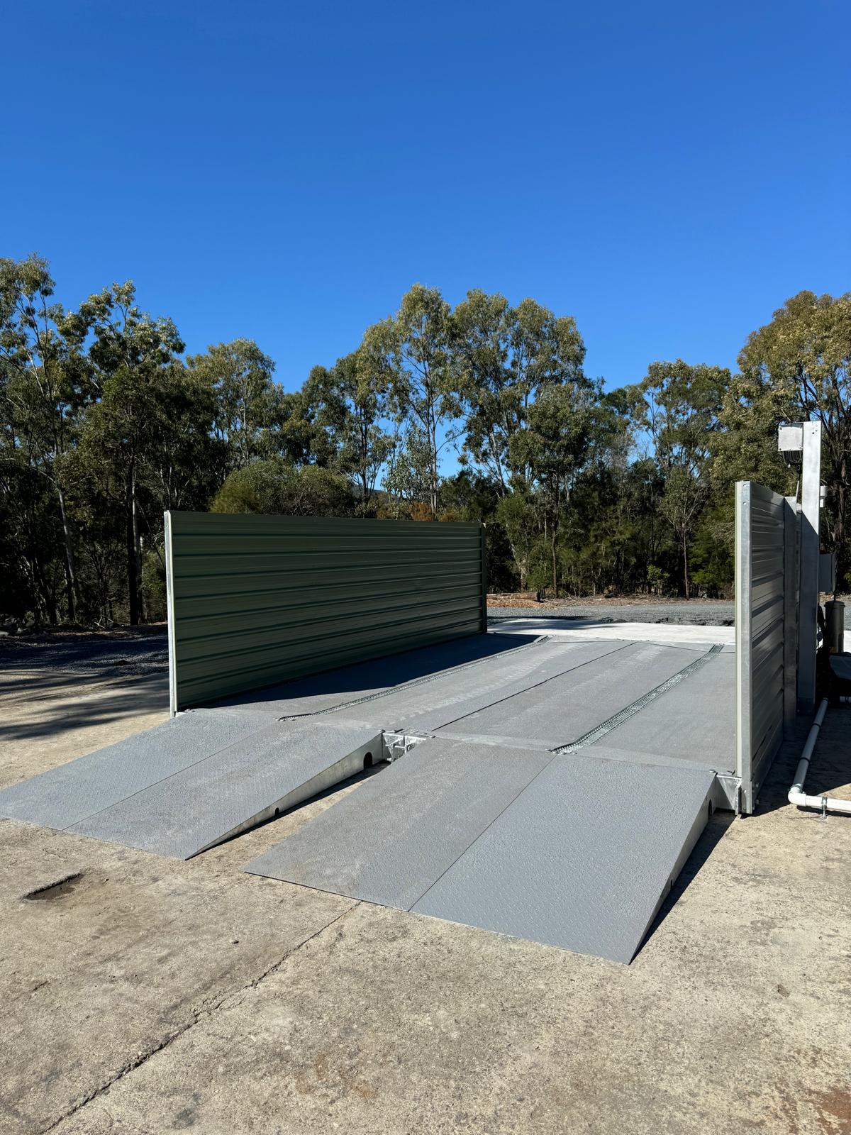 Washbay pump skid, pressure washer, controls and treatment equipment mounted beside washbay
