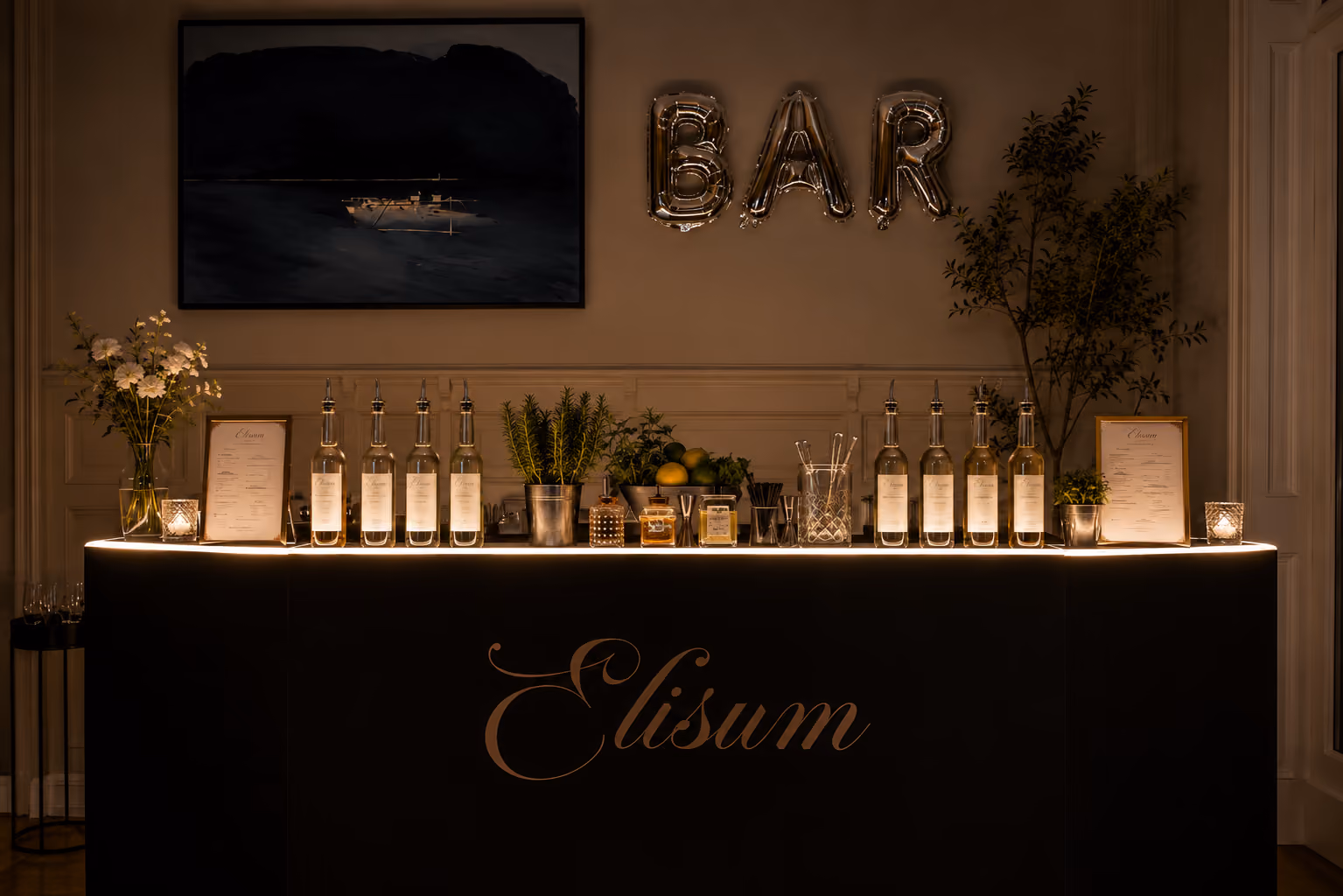 Elegant bar setup with bottles, plants, menus, and glowing 'BAR' balloons on a black counter labeled Elisum.
