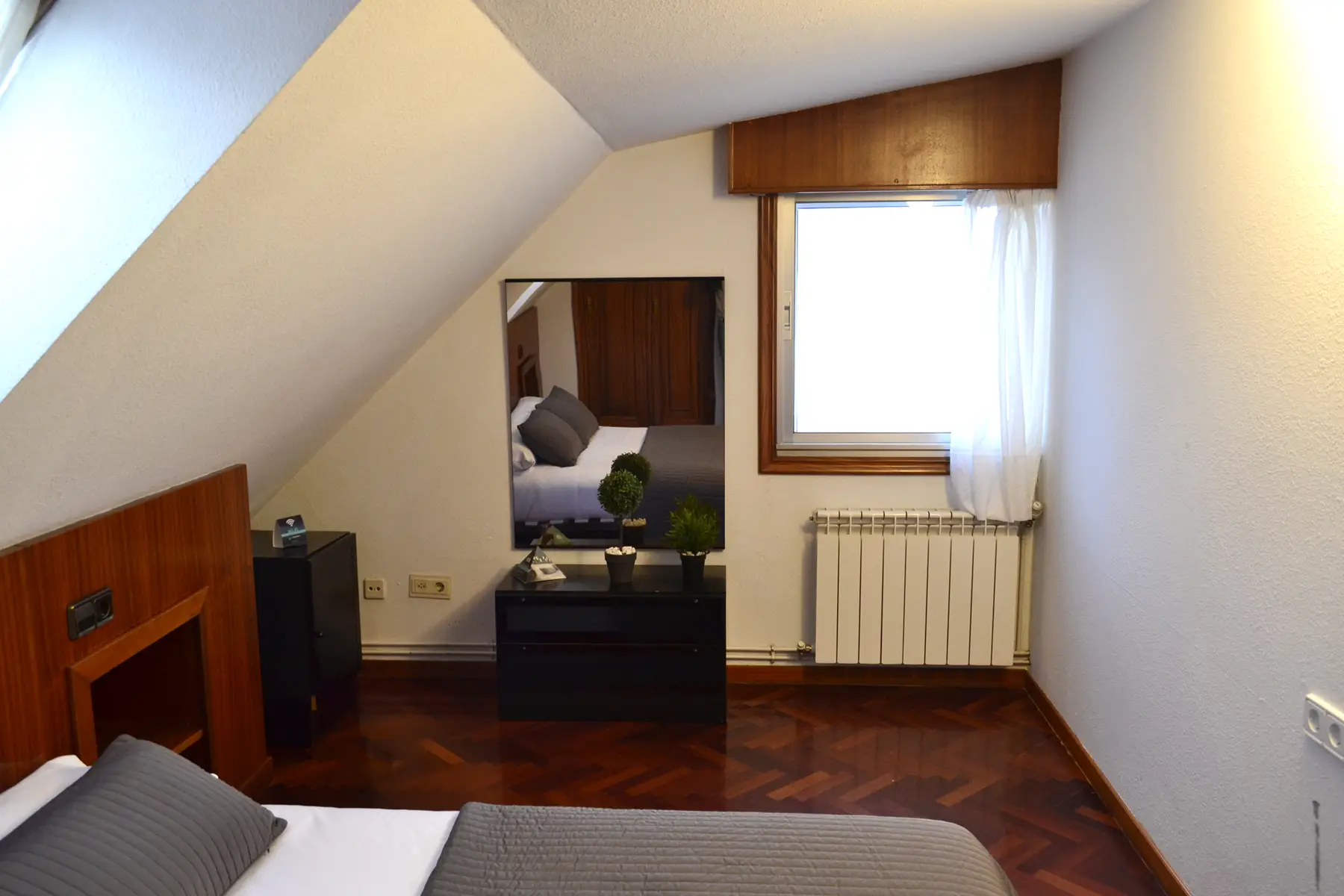 Dormitorio abuhardillado con espejo y cómoda — Estudio Estándar Vistas Ría, InsideHome Santa Cristina, Oleiros