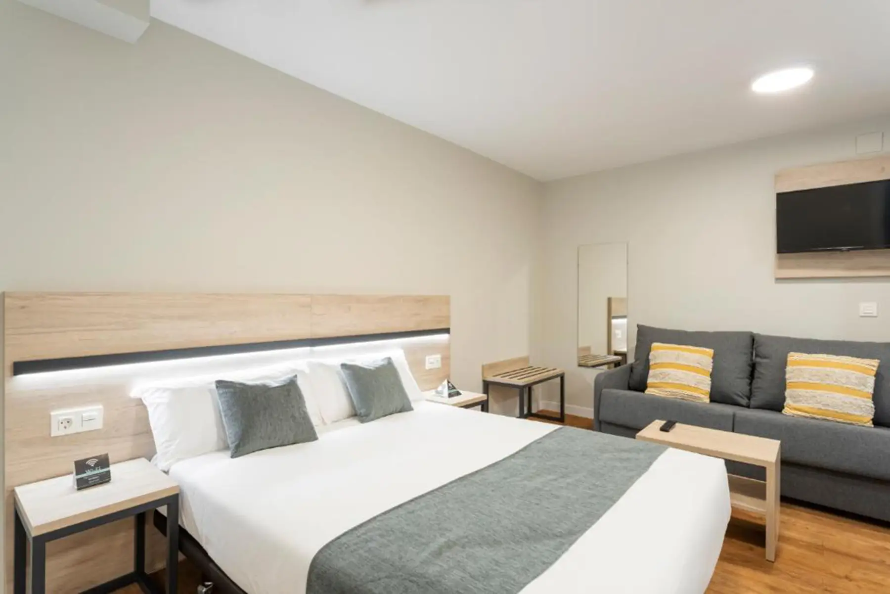 Cama doble junto al sofá — Estudio Interior, InsideHome Palencia Catedral, Palencia