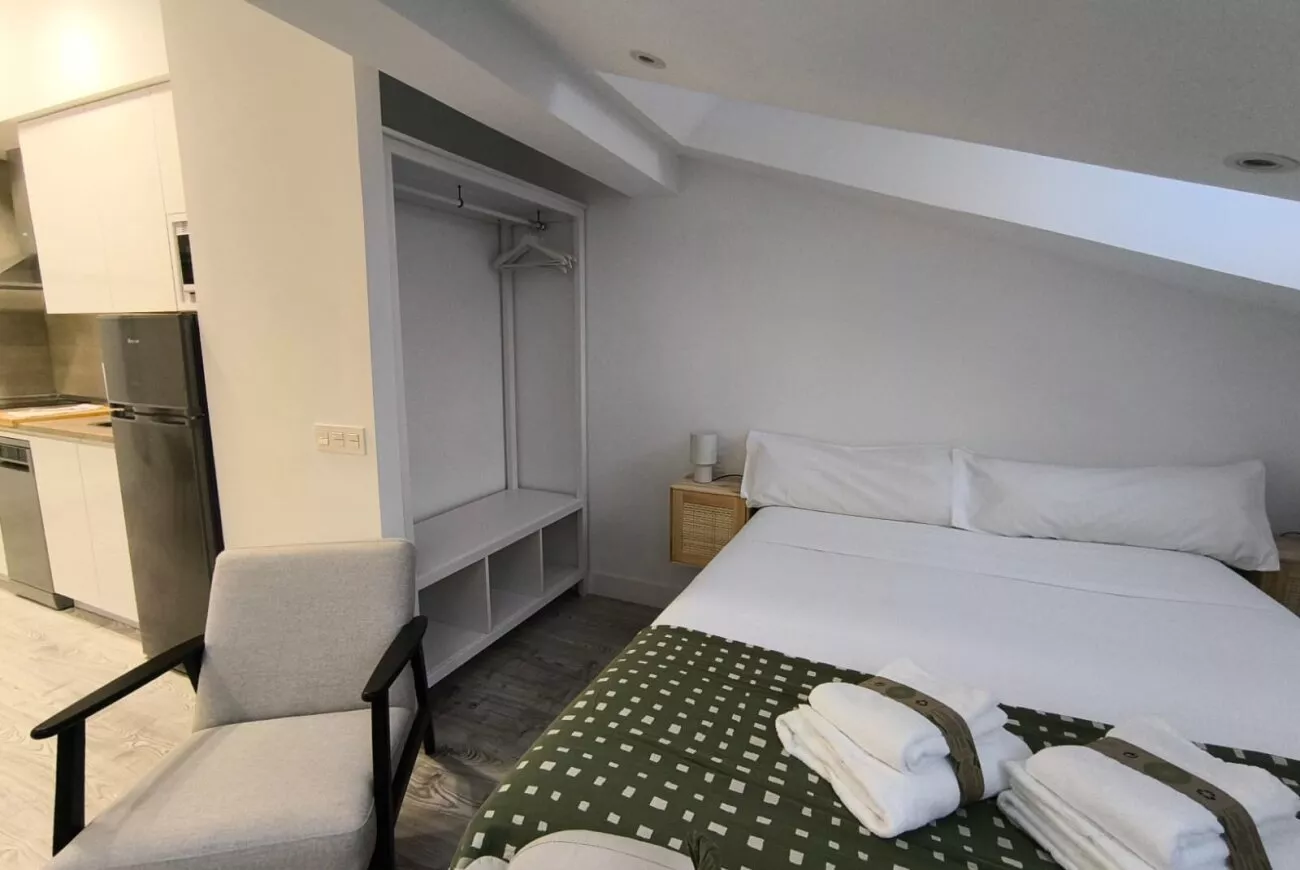 Cama doble junto al armario abierto — Estudio Ático, InsideHome Ciudad del Cine, Valladolid