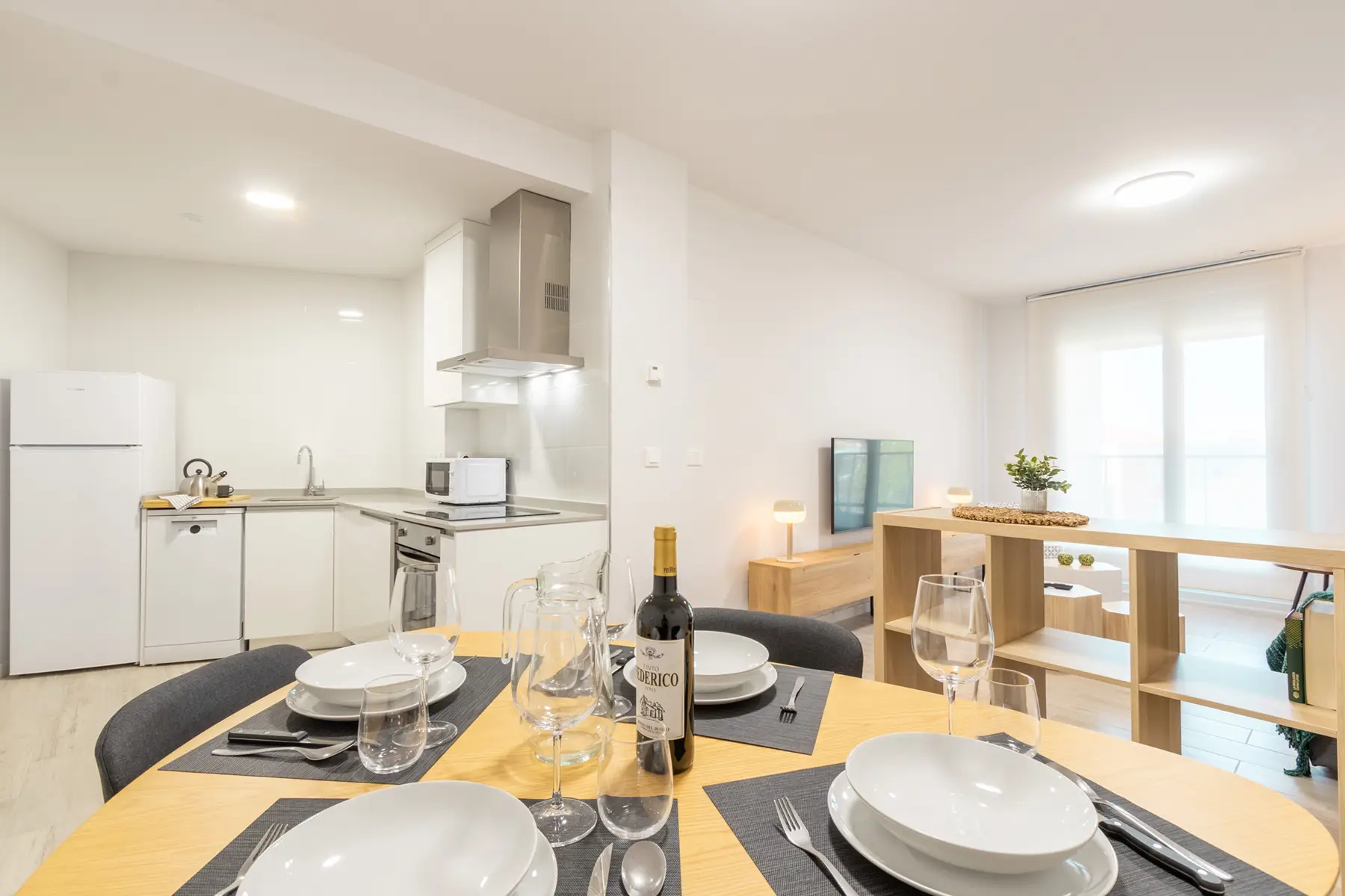 Mesa puesta con cocina al fondo — Apartamento de 1 Habitación - Estilo D, InsideHome Ciudad de Valladolid, Valladolid