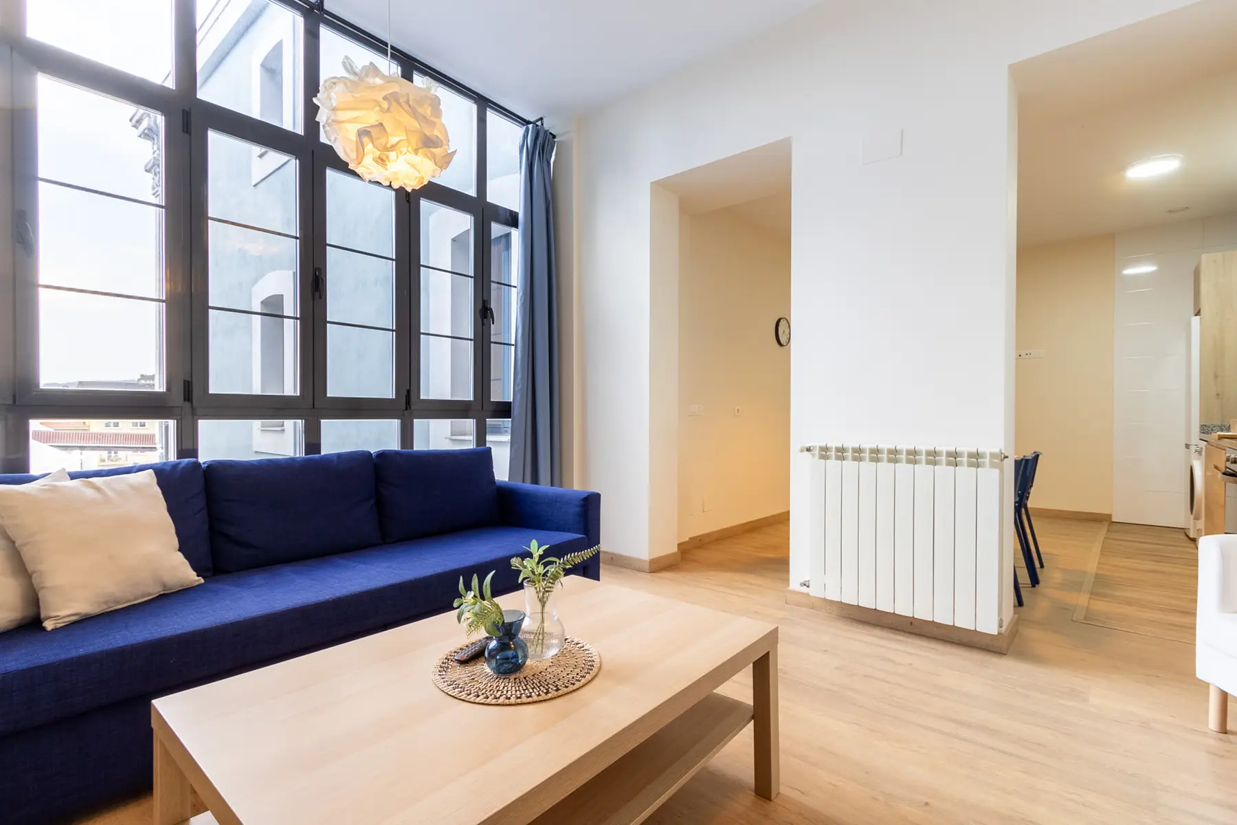 Salón con sofá azul y ventanal — Apartamento de 2 dormitorios - Estilo B, InsideHome Ciudad de Avilés, Avilés