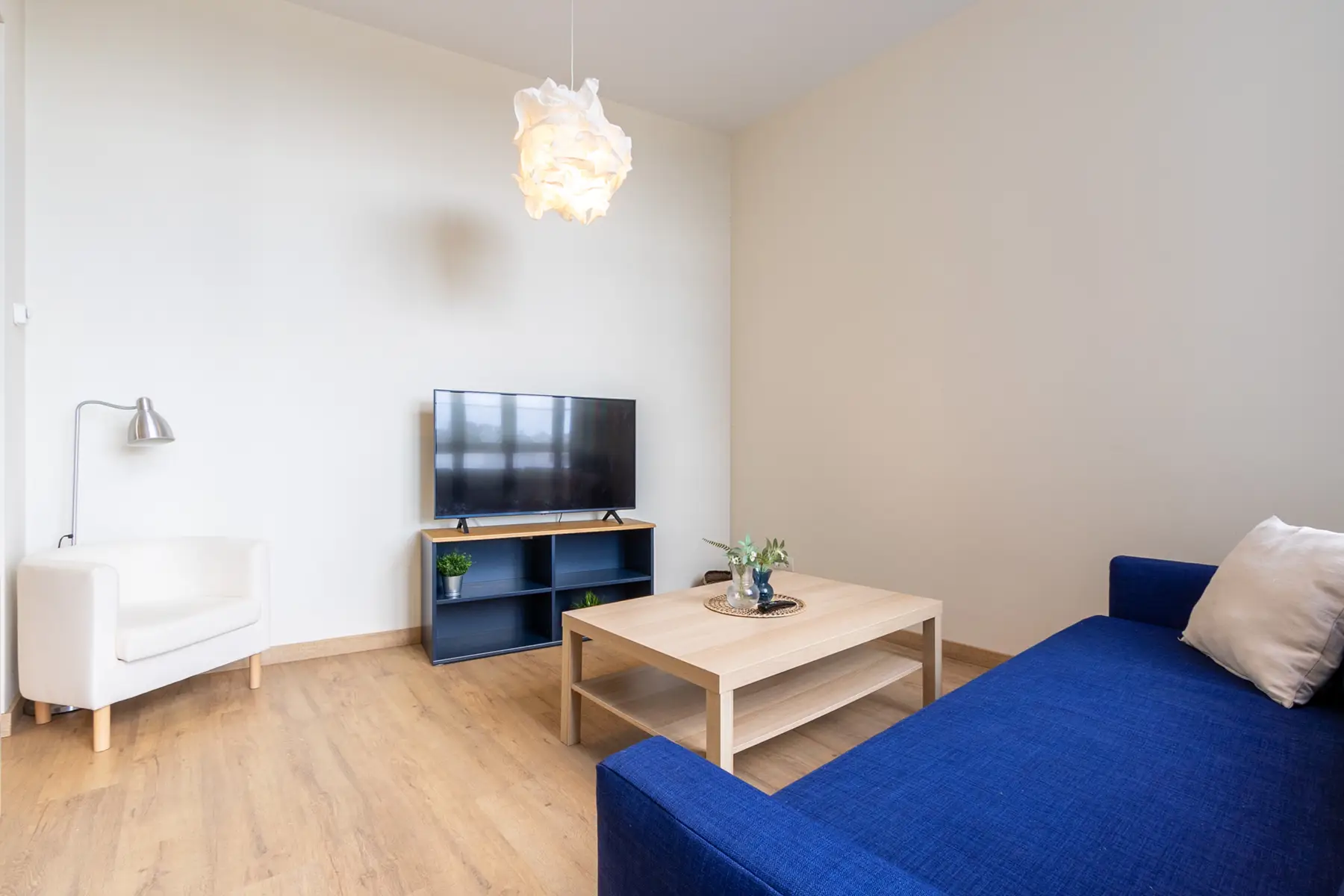 Salón con sofá azul y TV — Apartamento de 2 dormitorios - Estilo B, InsideHome Ciudad de Avilés, Avilés