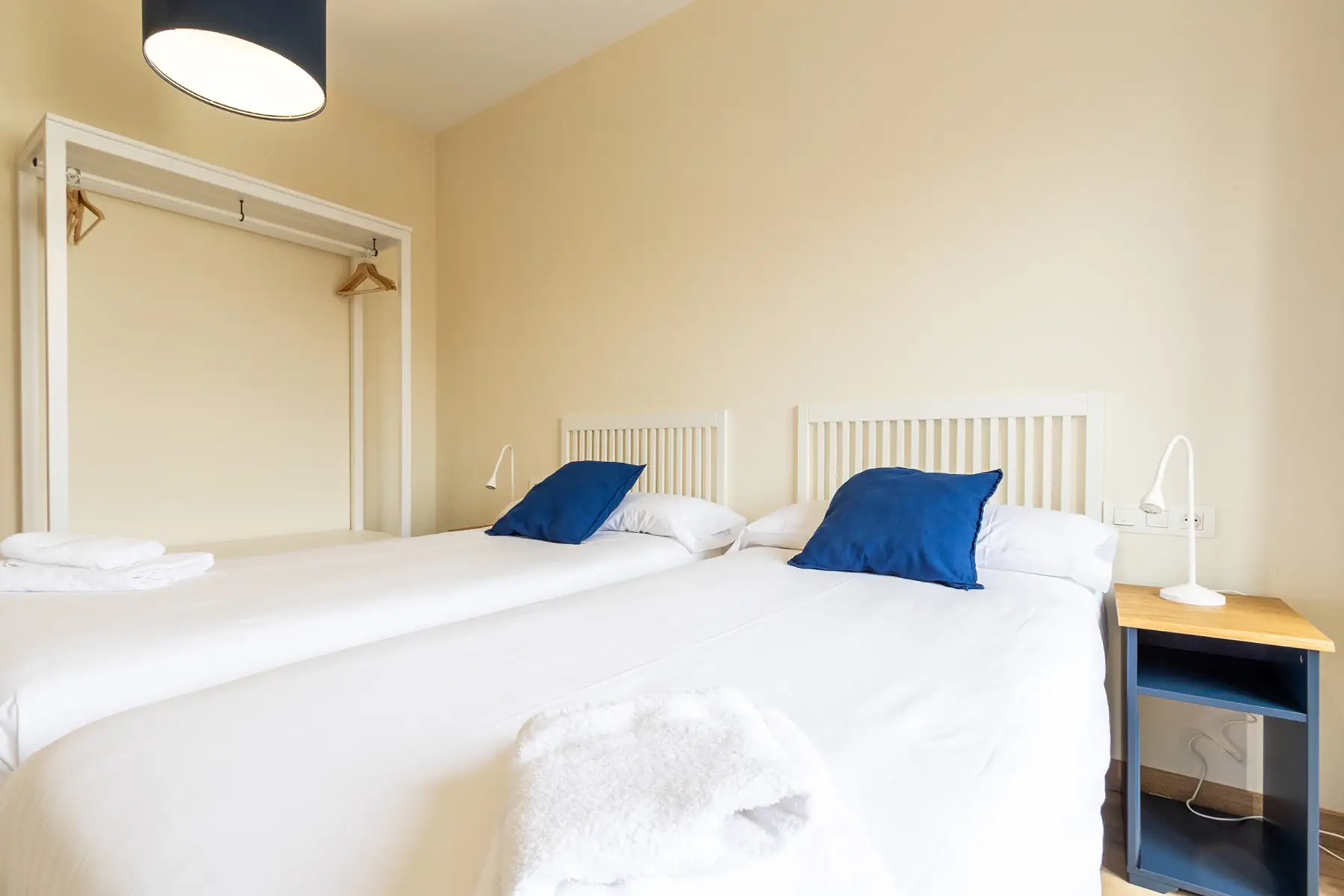Dormitorio con dos camas y perchero — Apartamento de 2 dormitorios - Estilo A, InsideHome Ciudad de Avilés, Avilés