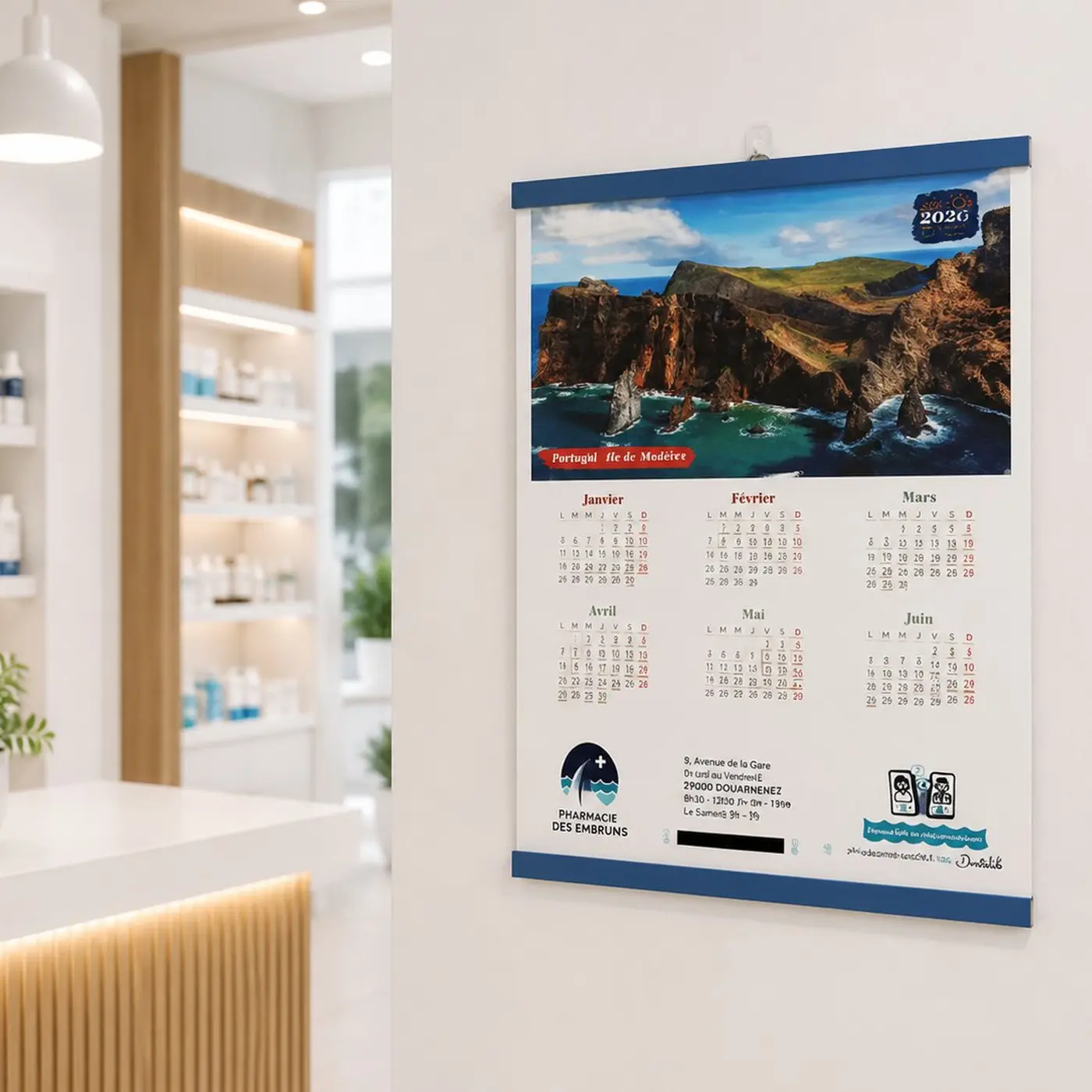 Calendrier mural 2020 avec photo de falaises en bord de mer, affiché dans une pharmacie moderne.