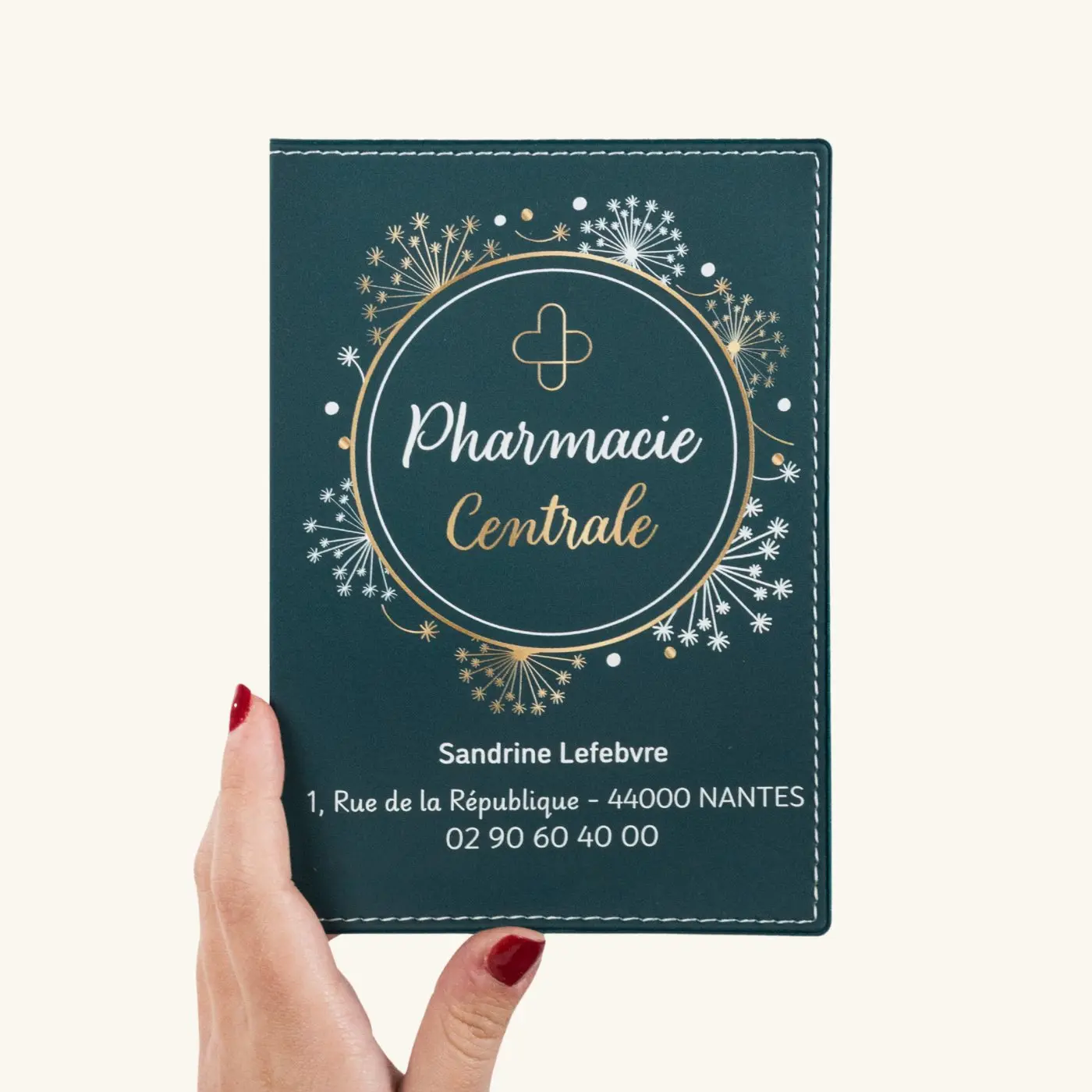 Carte de pharmacie verte tenue à la main avec le texte Pharmacie Centrale et coordonnées à Nantes.