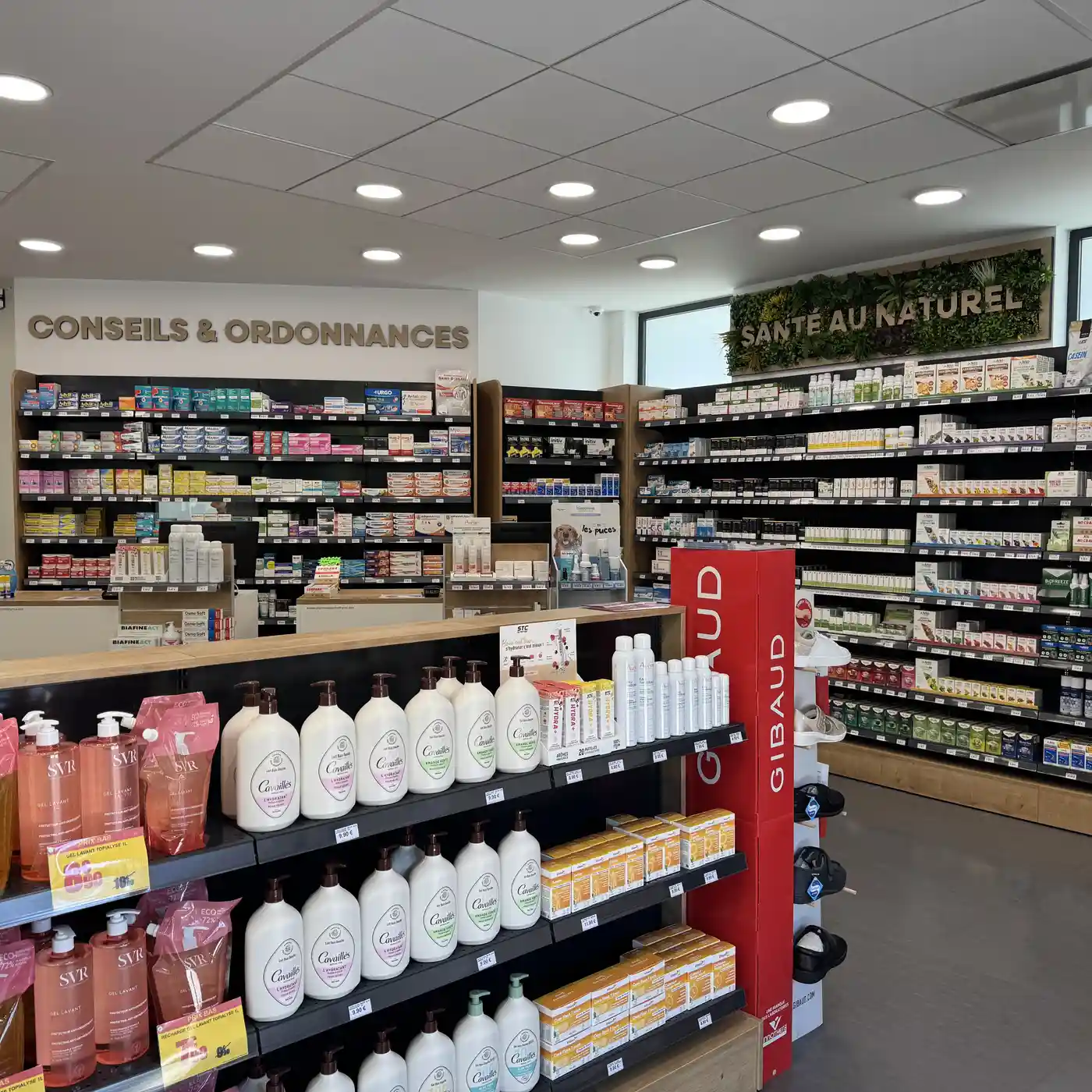 Intérieur d'une pharmacie avec rayons de produits de santé et cosmétiques.