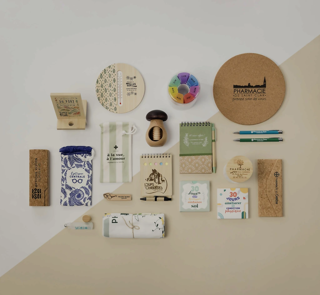 Objets divers liés à une pharmacie, dont pince-miel, pilulier, bloc-notes, stylos et sacs en tissu.