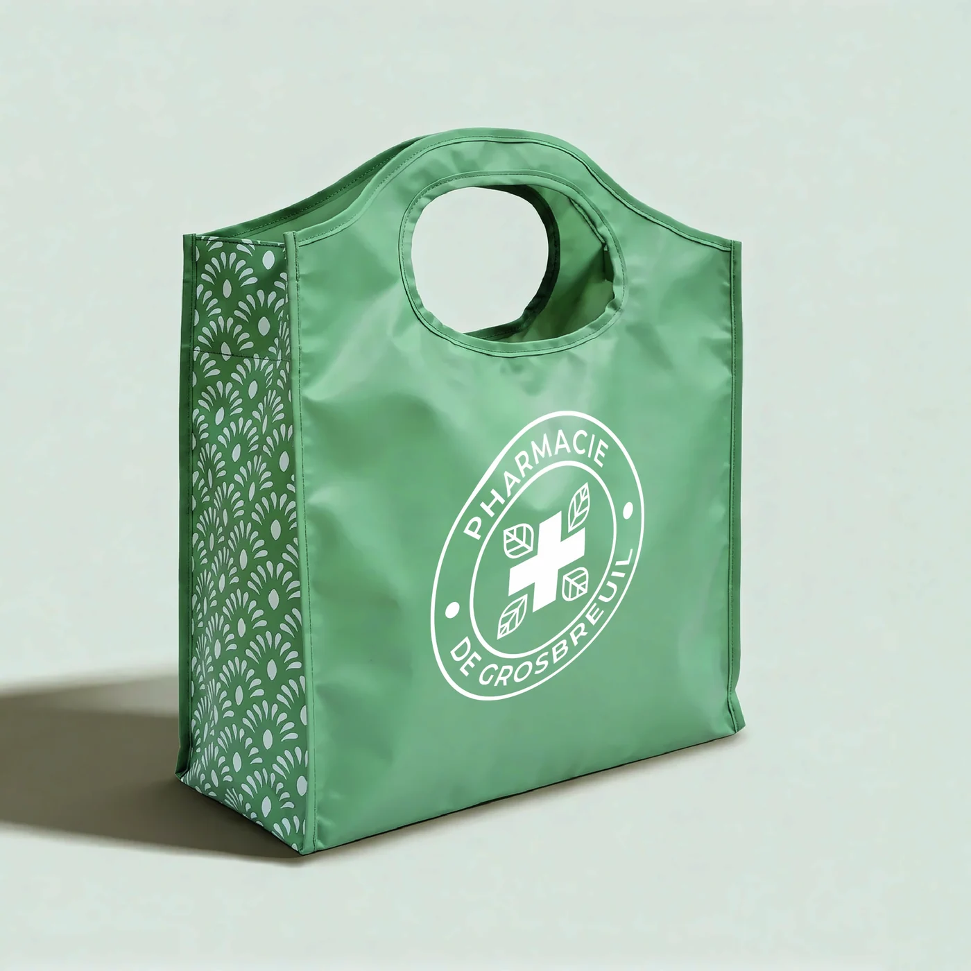 Sac vert réutilisable avec logo Pharmacy de Grosbreuil et motifs décoratifs sur le côté.