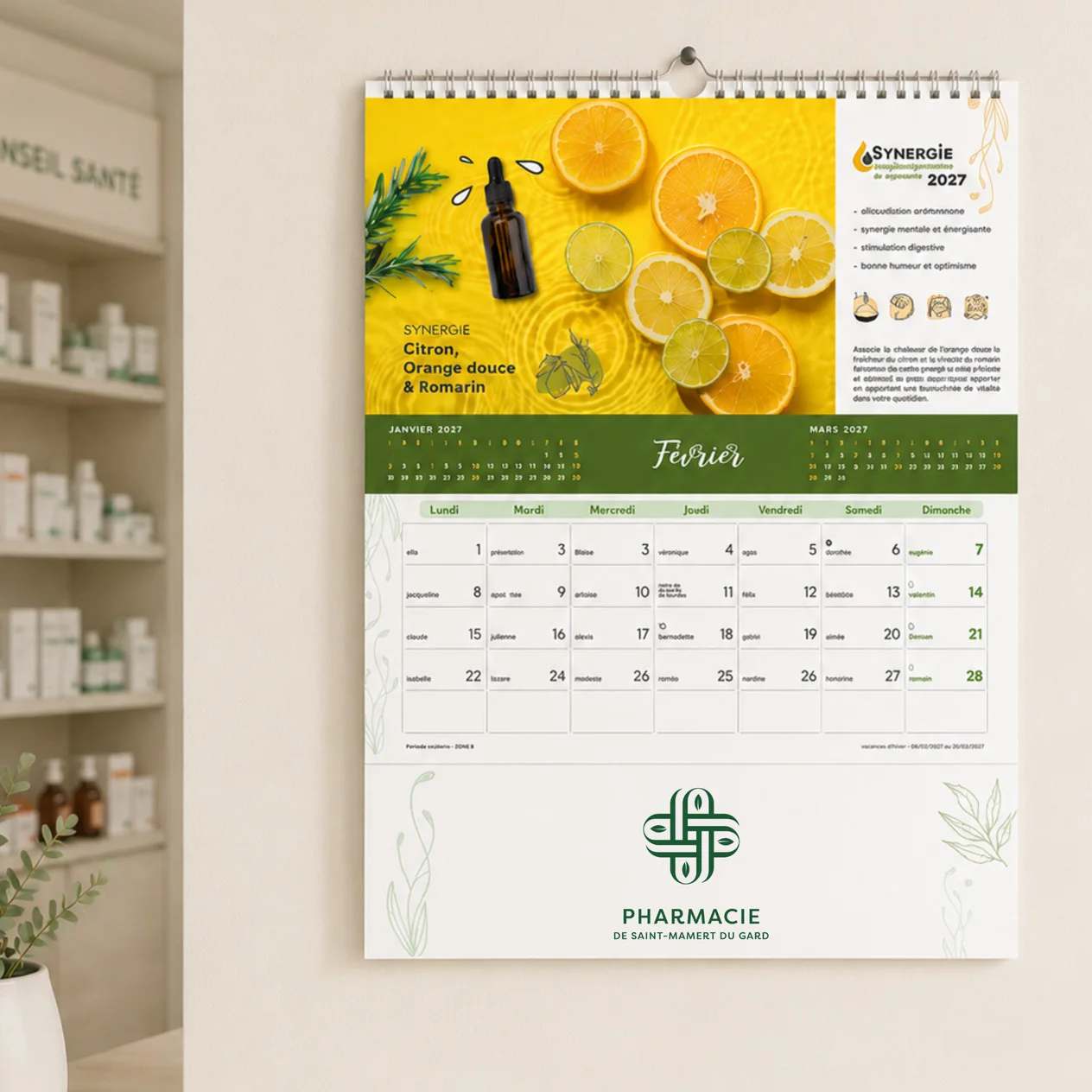 Calendrier de février 2027 avec des agrumes, flacon d’huile essentielle et logo pharmacie.