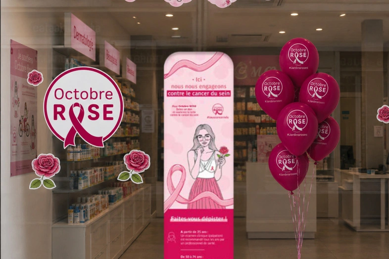 Vitrine avec affiches et ballons roses pour Octobre Rose, campagne contre le cancer du sein.