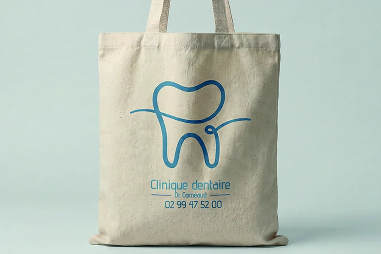 Sac tote beige avec un logo de dent stylisé et texte cliniquedentaire Dr. Corneaud et numéro de téléphone.