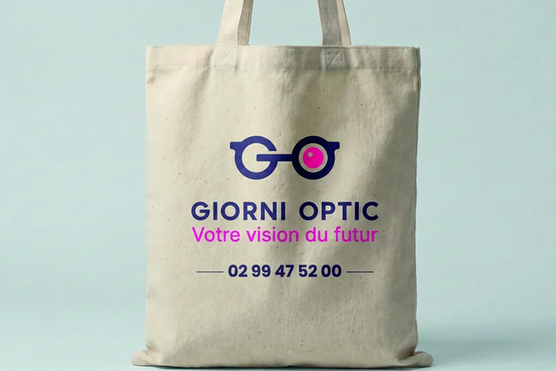 Sac tote en tissu avec logo lunettes et texte Giorni Optic, slogan et numéro de téléphone.