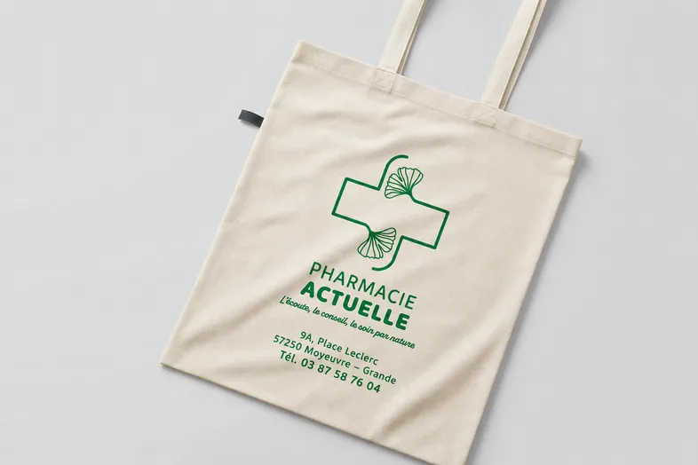 Sac en tissu beige avec logo vert Pharmacie Actuelle et coordonnées de Moyevre-Grande.