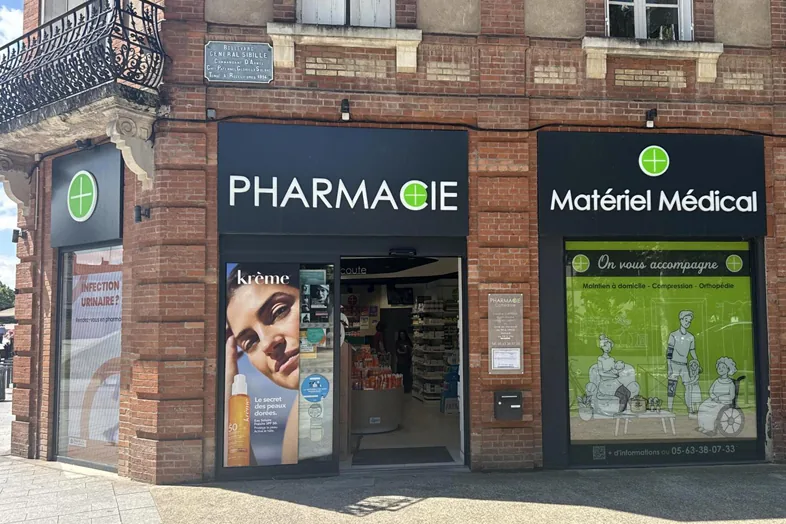 Façade d'une pharmacie et d'un magasin de matériel médical dans un bâtiment en brique.