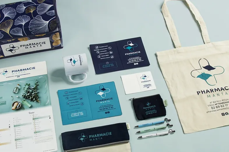 Papeterie et accessoires de marque pour Pharmacie Manta avec logo raies manta sur fond bleu clair.