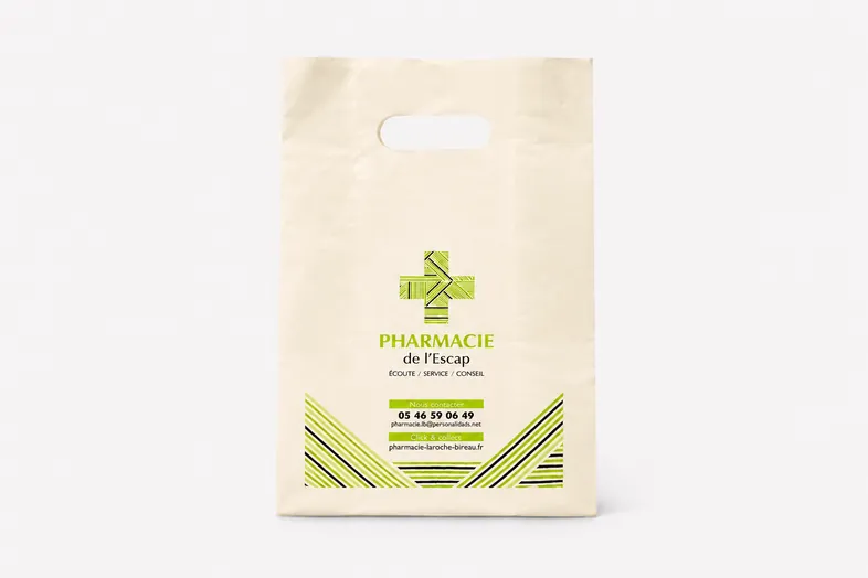 Sac en papier beige de la Pharmacie de l'Escap avec logo croix verte et informations de contact.