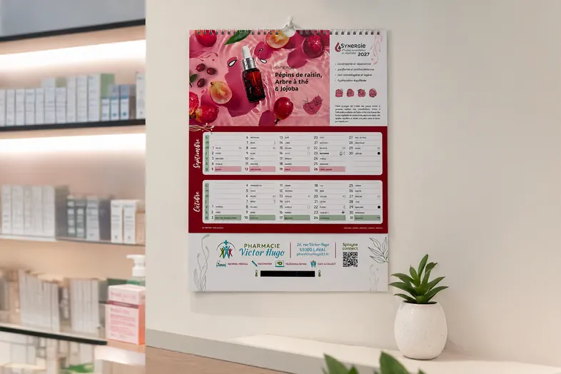 Calendrier mural 2027 avec illustration de soin et calendrier septembre-octobre accroché sur un mur blanc.
