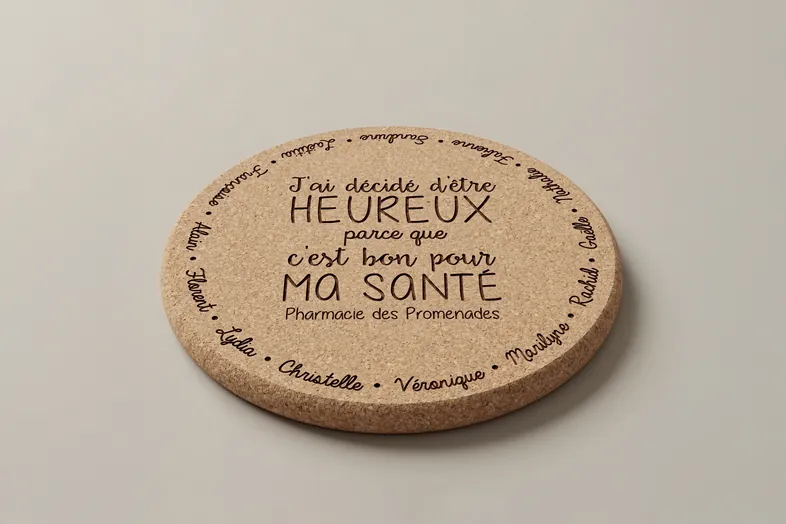 Dessous de plat rond en liège avec message positif en français de Pharmacie des Promenades.