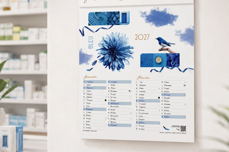 Calendrier mural 2027 bleu avec fleur, oiseau et ruban, montrant les mois de janvier et février.