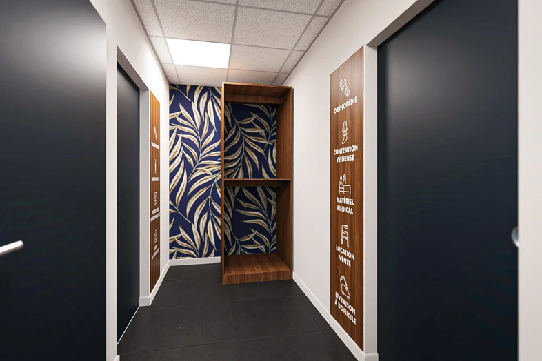 Couloir moderne avec portes noires, murs blancs et motif feuillage bleu et beige au fond.