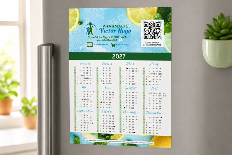 Calendrier 2027 de la Pharmacie Victor Hugo avec QR code, affiché sur un réfrigérateur.