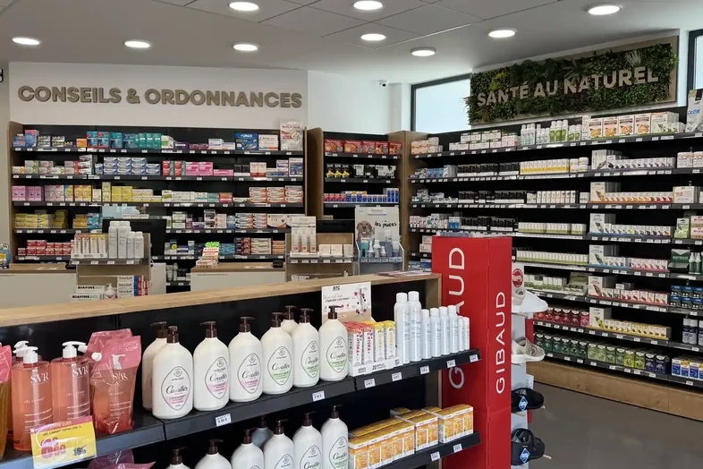 Intérieur d'une pharmacie avec rayons de médicaments, produits de santé et cosmétiques en vente.
