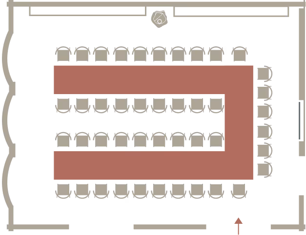 Floor plan of a rectangular conference room with U-shaped table configuration and chairs around it, including an entrance marked with an arrow at the bottom right.