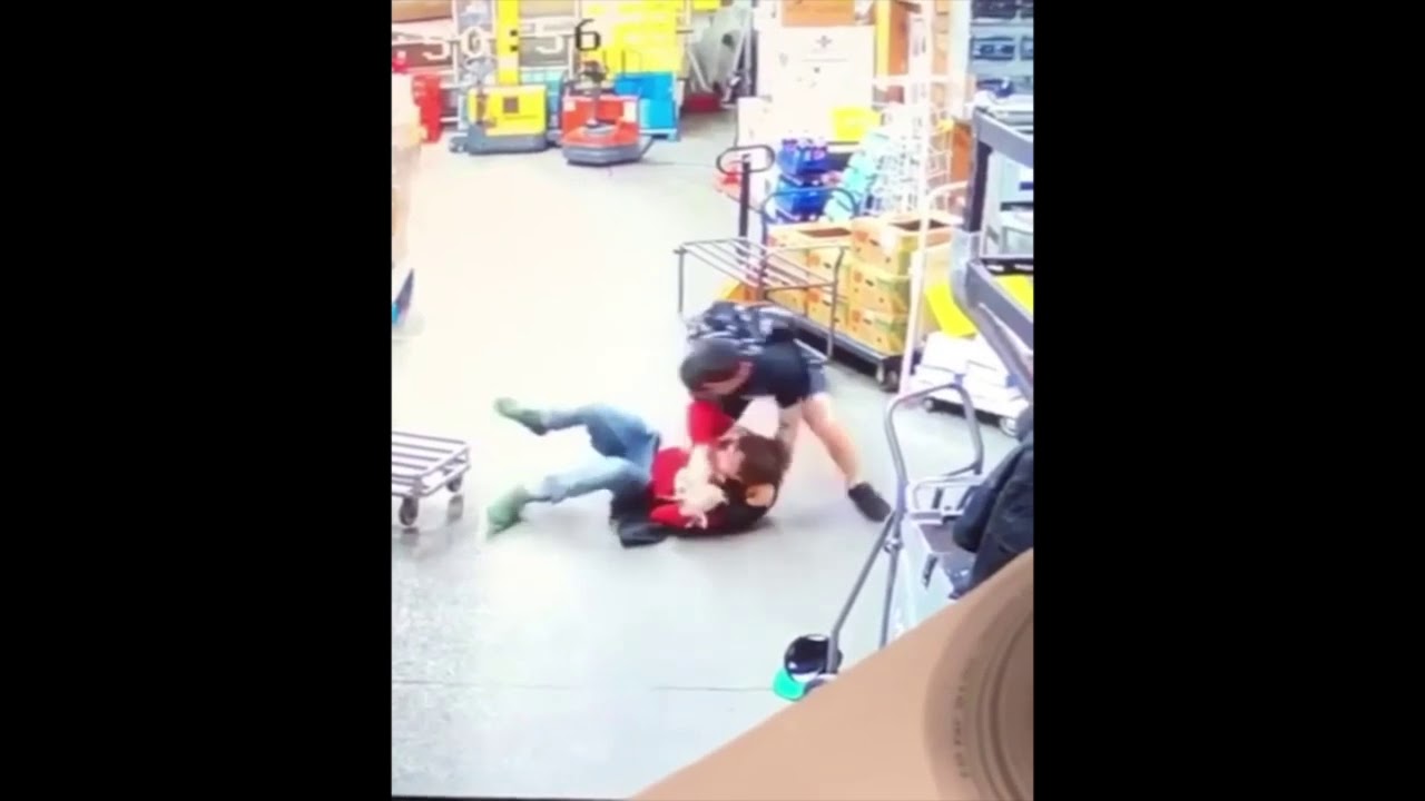 Video still: security guard pinning a shoplifter to the floor inside a store