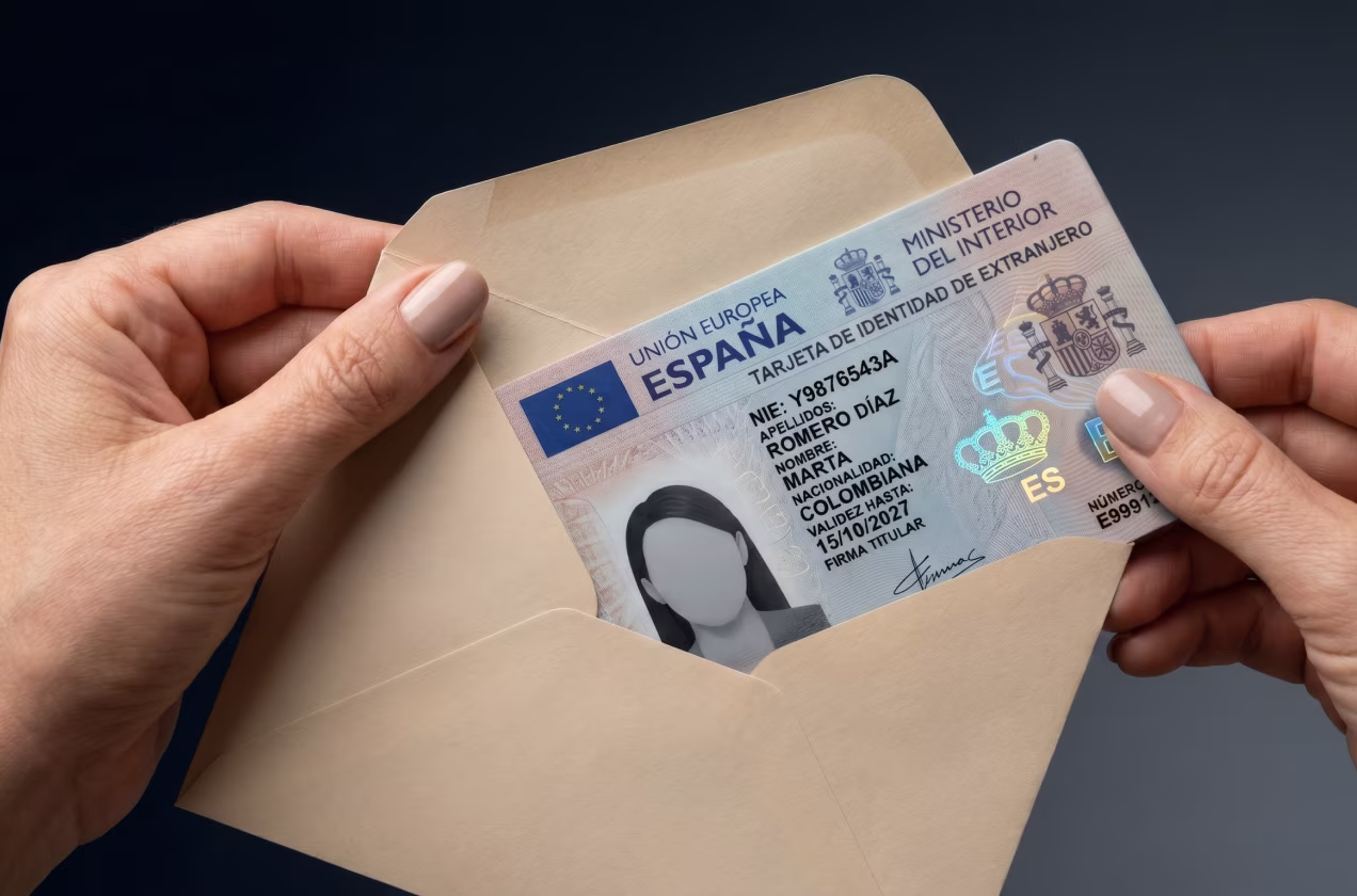 Hands holding an envelope with a Spanish foreigner identity card inside.