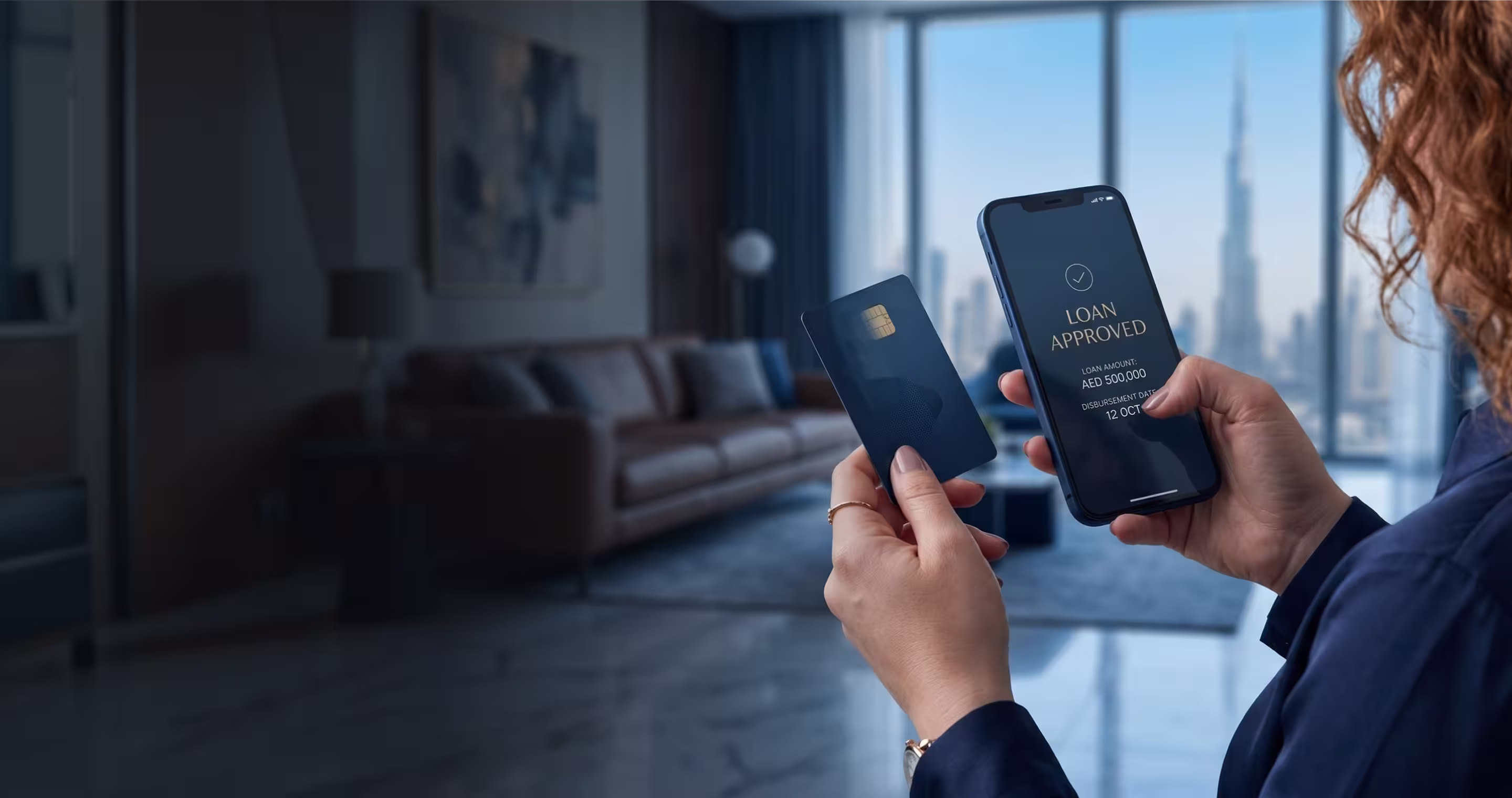 Person holding credit card and smartphone showing loan approved