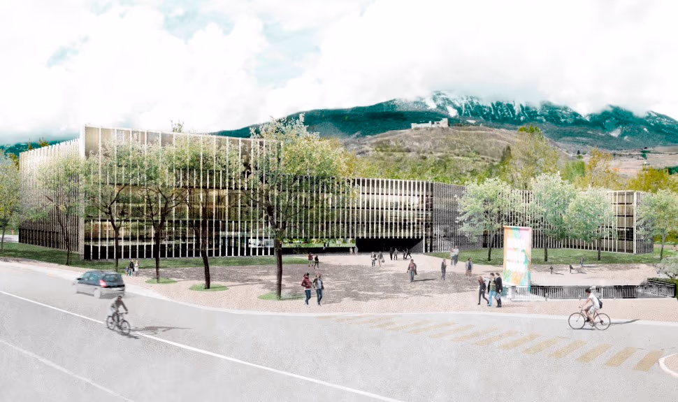 Bâtiment moderne en verre et métal entouré d’arbres, avec des piétons et cyclistes devant, et une montagne partiellement couverte de nuages en arrière-plan.