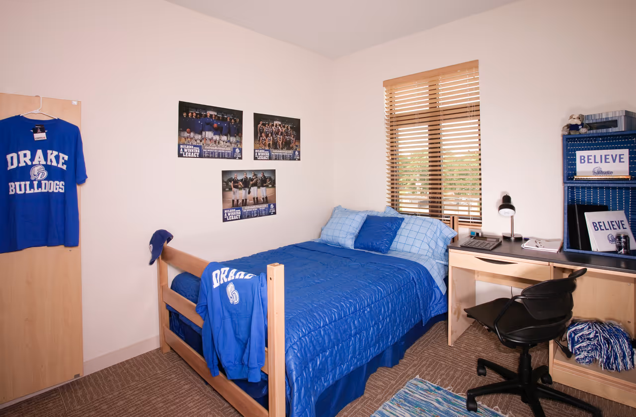 Bedroom with bed, desk and Drake University decor