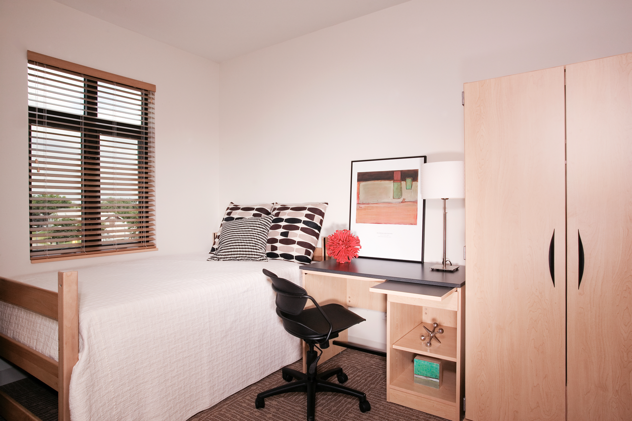 Bedroom with bed, desk, large window and wardrobe