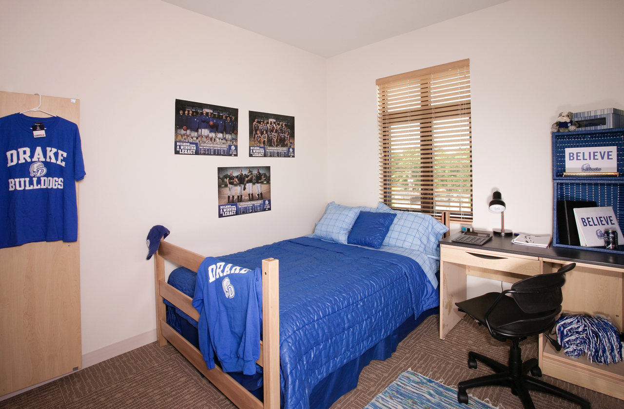 Bedroom with bed, desk, and Drake University decor