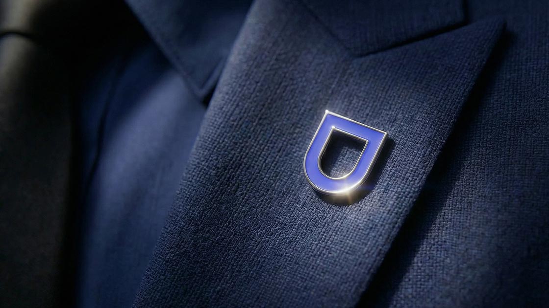 plano close de um pin com marca defensive na lapela de um terno