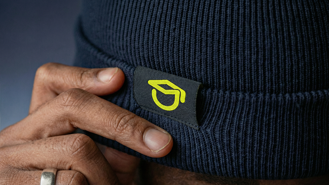 plano detalhe de uma touca preto carvao do signo desensive academy em uma etiqueta.