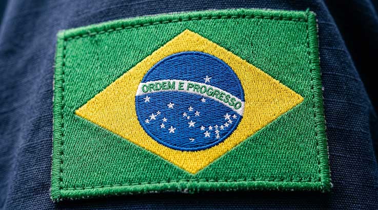 Bandeira do Brasil bordada em tecido azul com lema Ordem e Progresso.