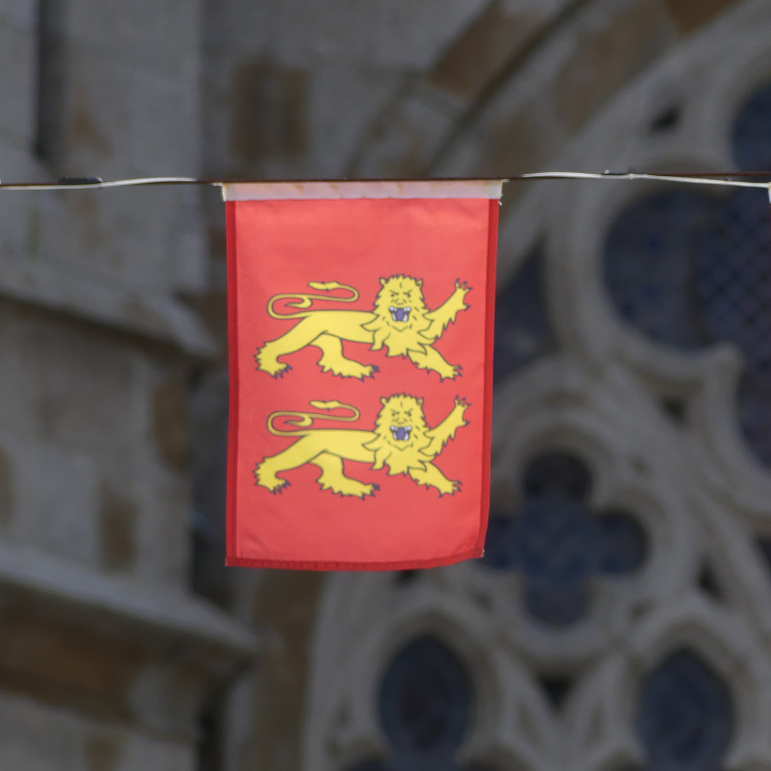 Drapeau de la Normandie devant un édifice gothique
