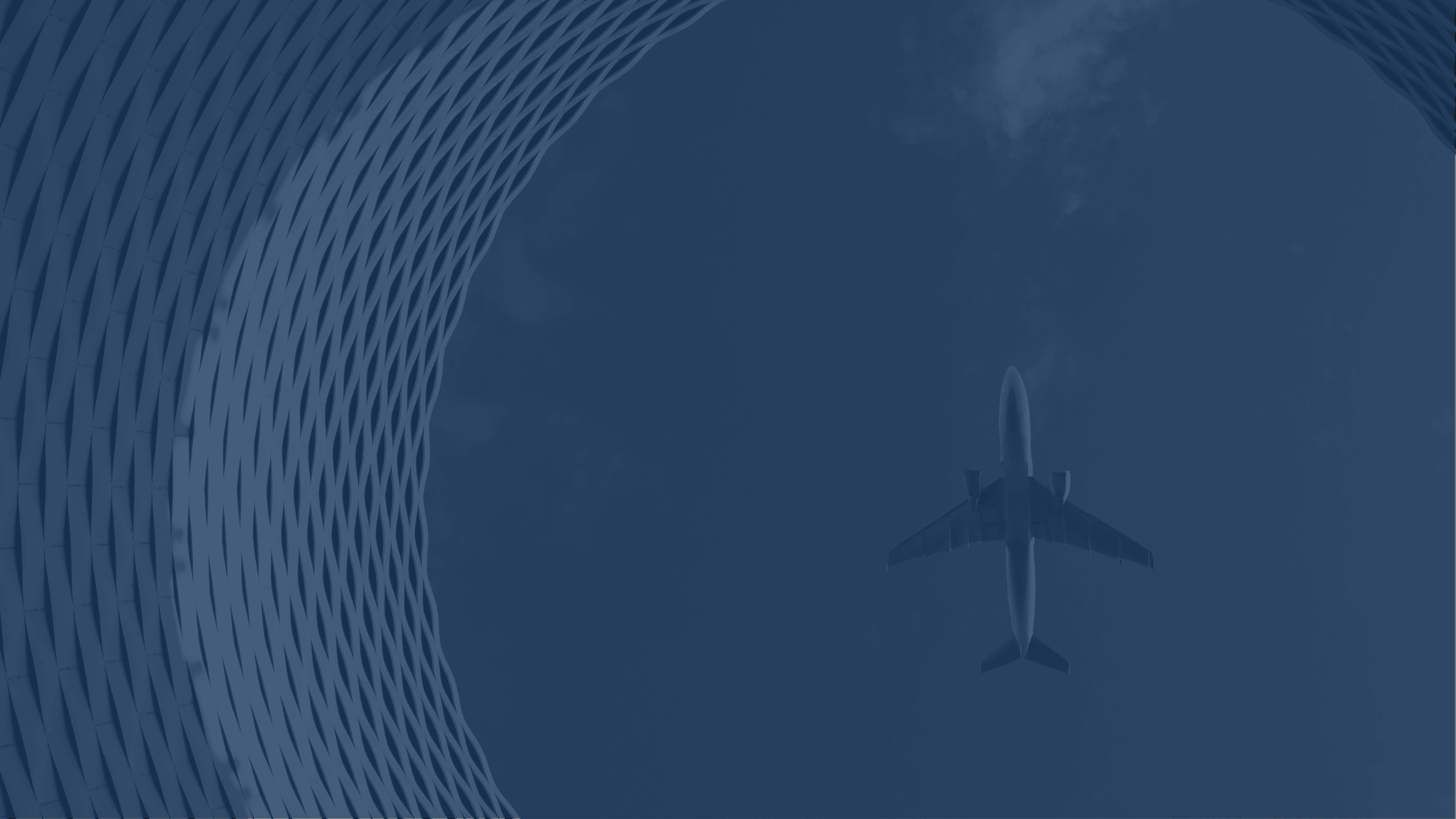 Airplane flying overhead seen through circular architectural lattice structure.