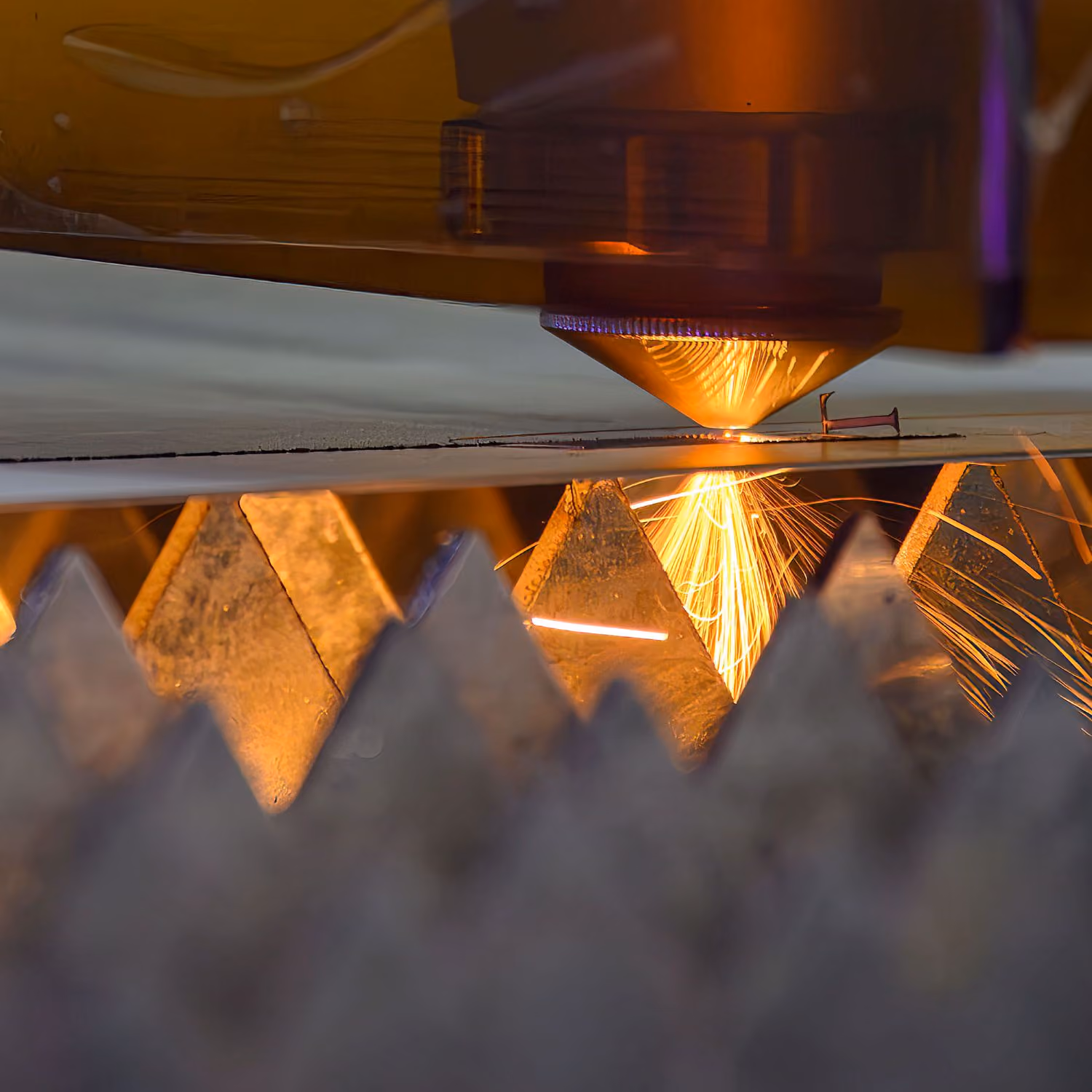 Close-up of a CNC laser cutting machine cutting metal sheet.