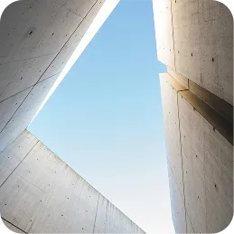 View of blue sky framed by tall, gray concrete walls with sharp angular edges.
