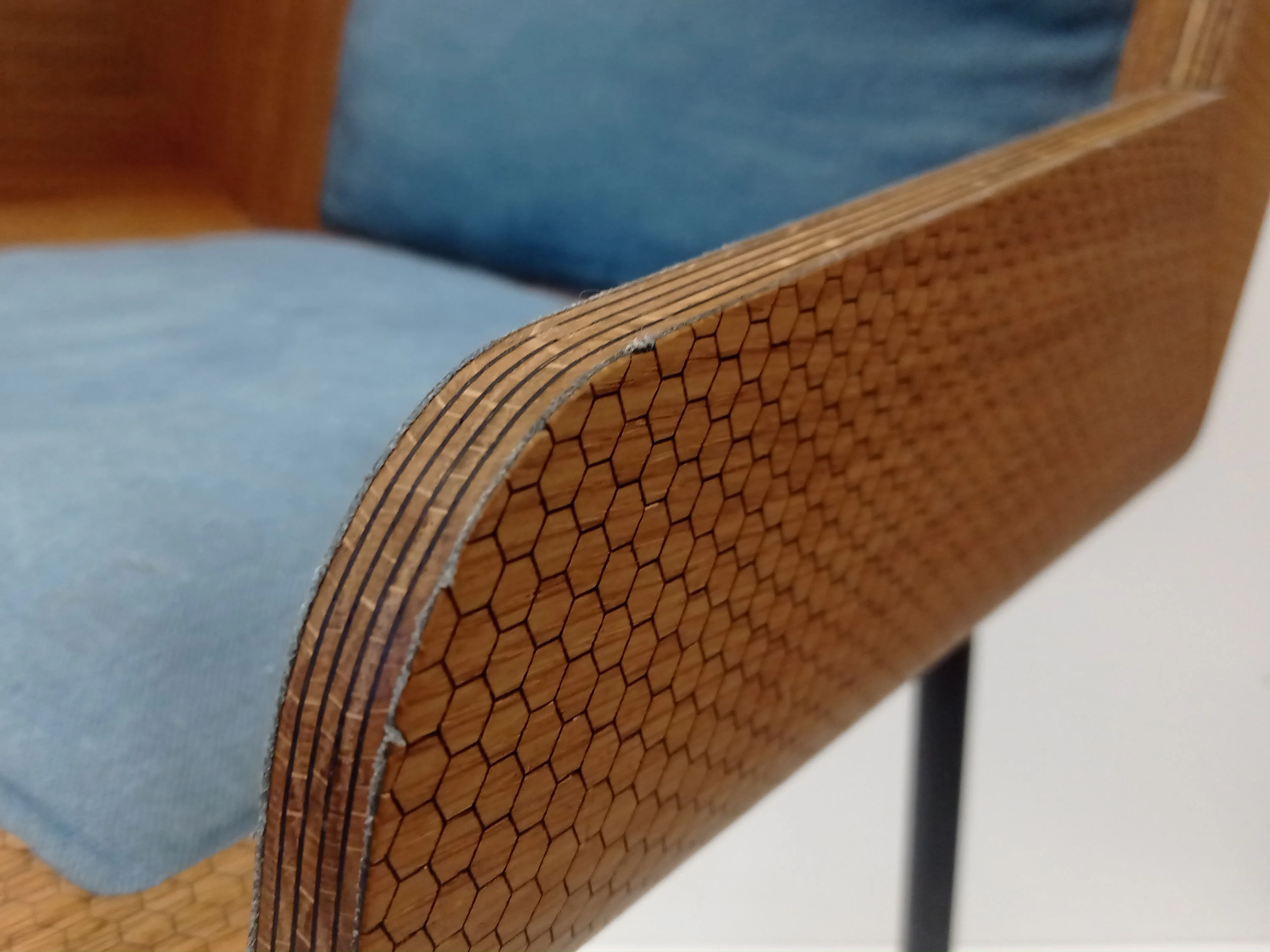 Zoom sur le détail des feuilles de placage alternant entre le chêne naturel et le chêne teinté, formant la coque de l'assise