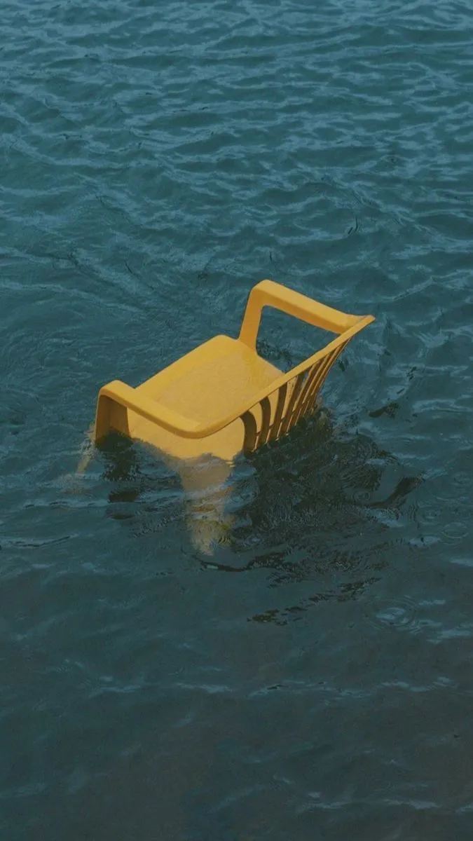 Chaise jaune à moitié immergée dans l'eau