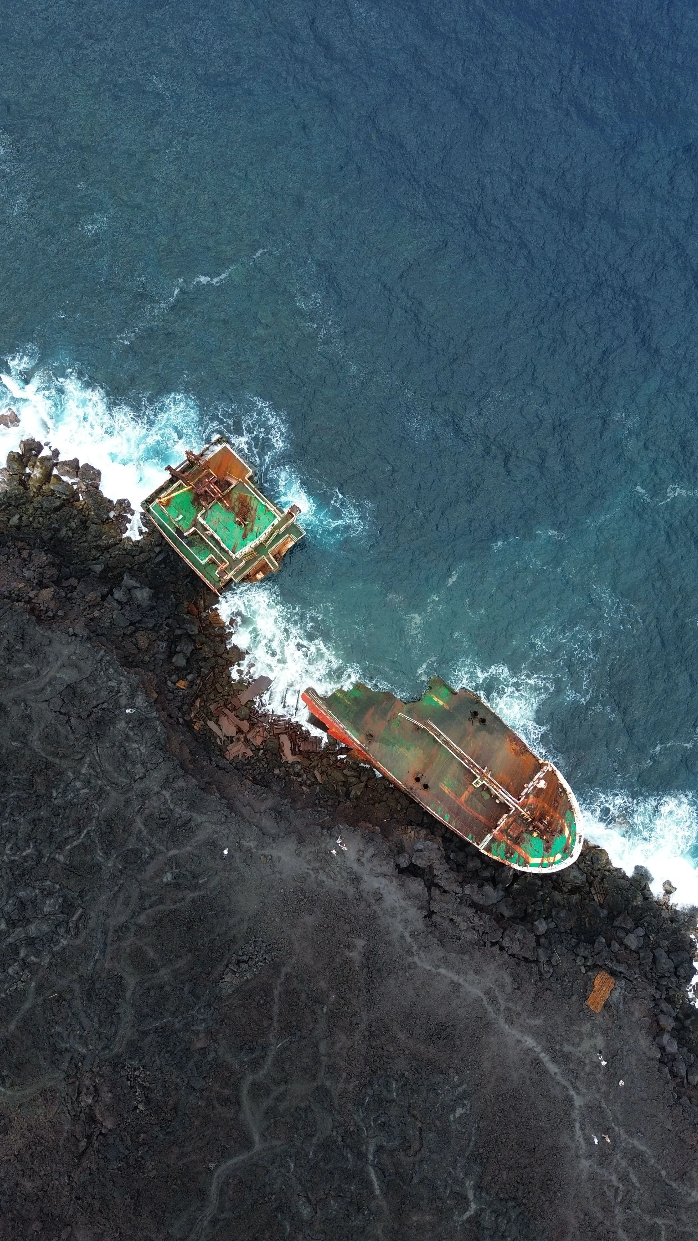 Vue aérienne d'une épave de navire échouée sur une côte de roches volcaniques