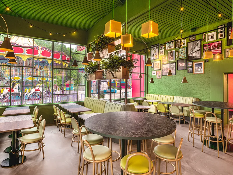 Groen restaurant in Walibi met gele hanglampen, festivalverlichting aan het plafond en een compleet lichtplan op maat