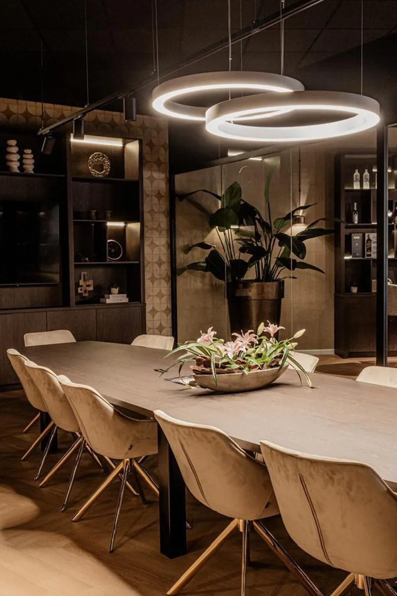 Luxe vergaderruimte bij House of Capital met witte LED-ringlampen boven lange tafel en indirecte wandverlichting in kasten