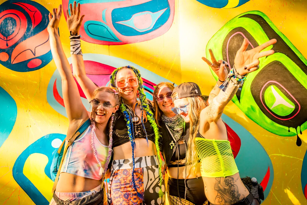 4 people at Shambhala music festival 2023 in front of freshly painted mural during the festival