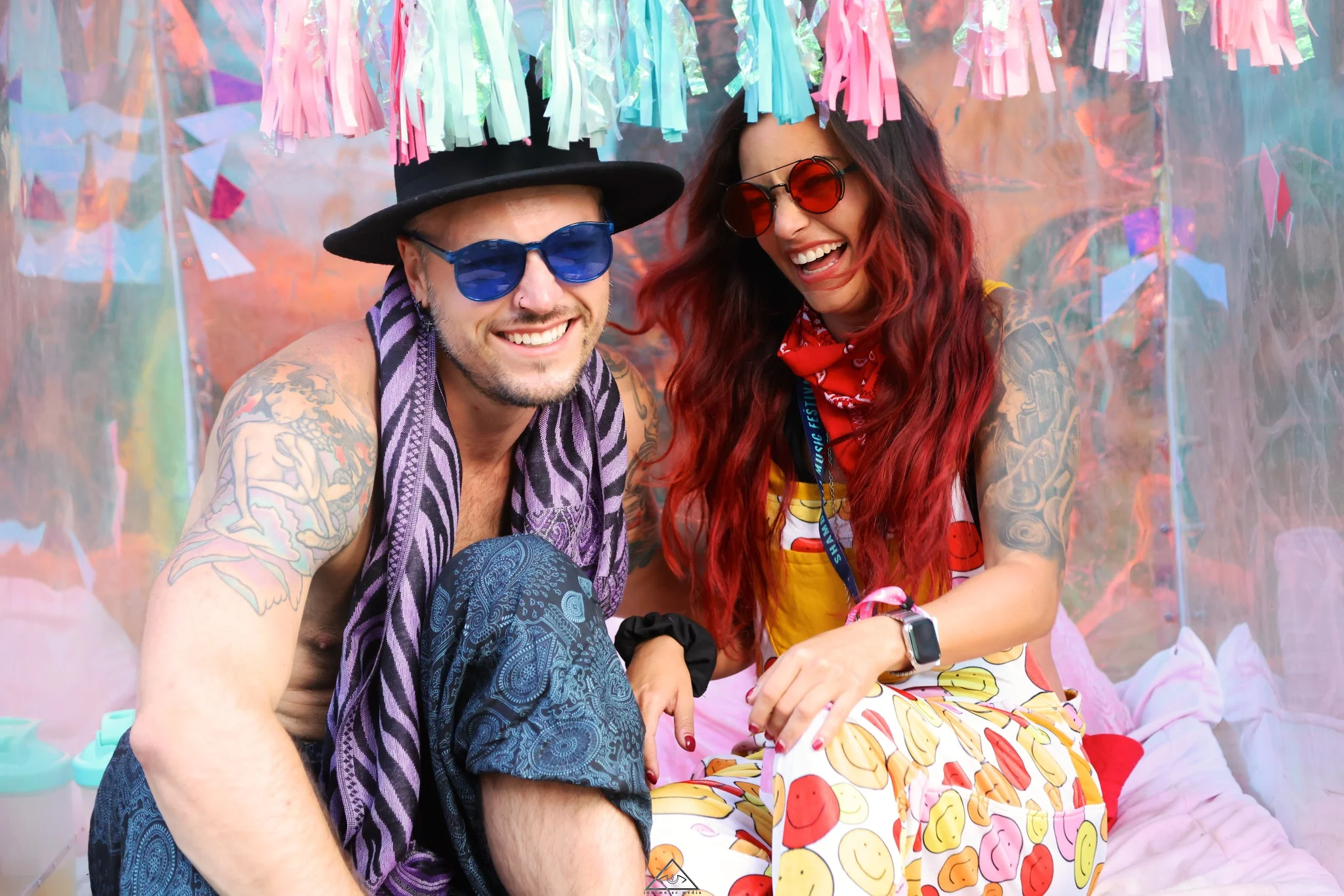 Two friends laughing under a decorate art instalment at Shambhala Music Festival 2023 